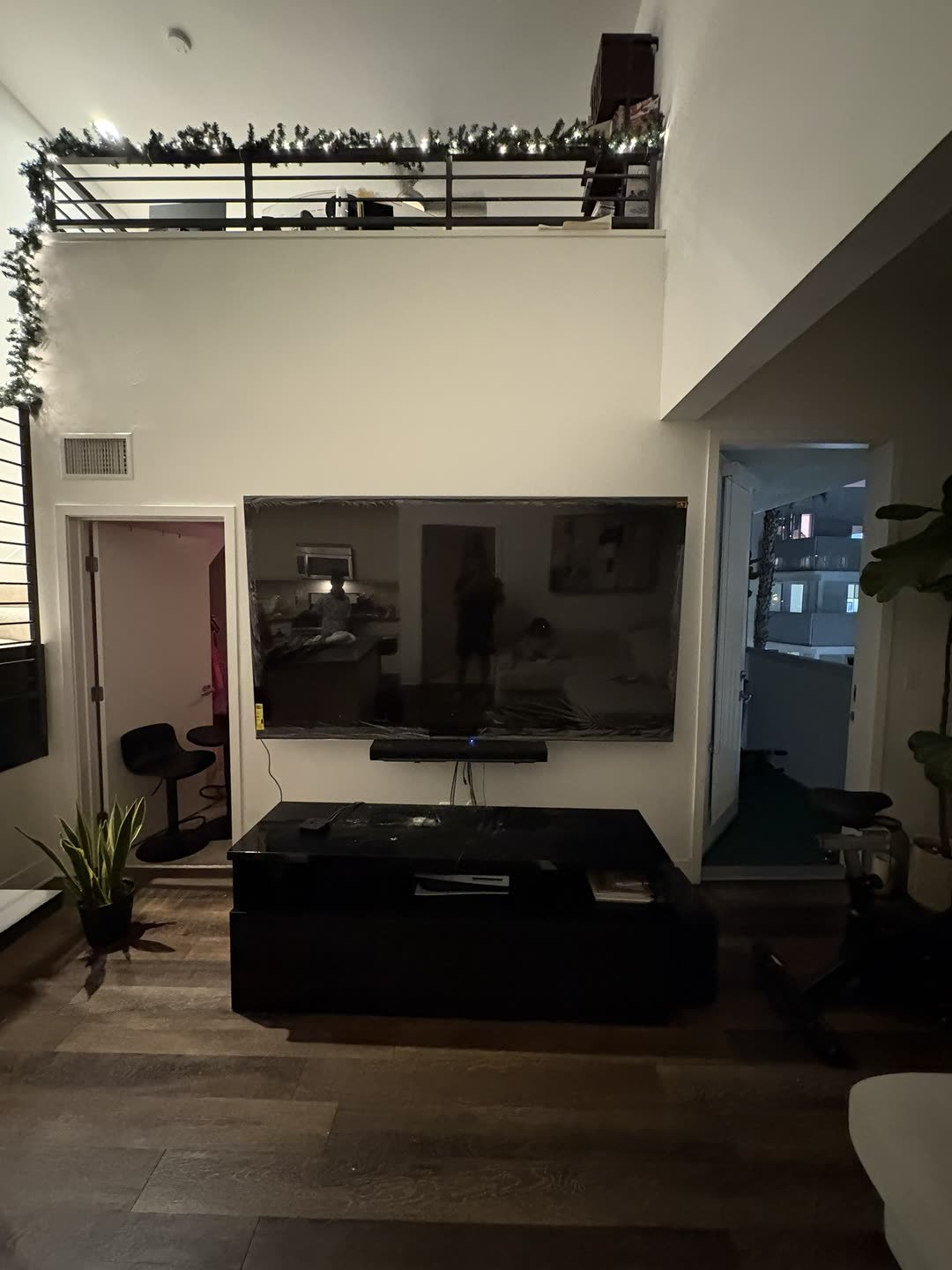 Large TV with soundbar mounted in loft apartment