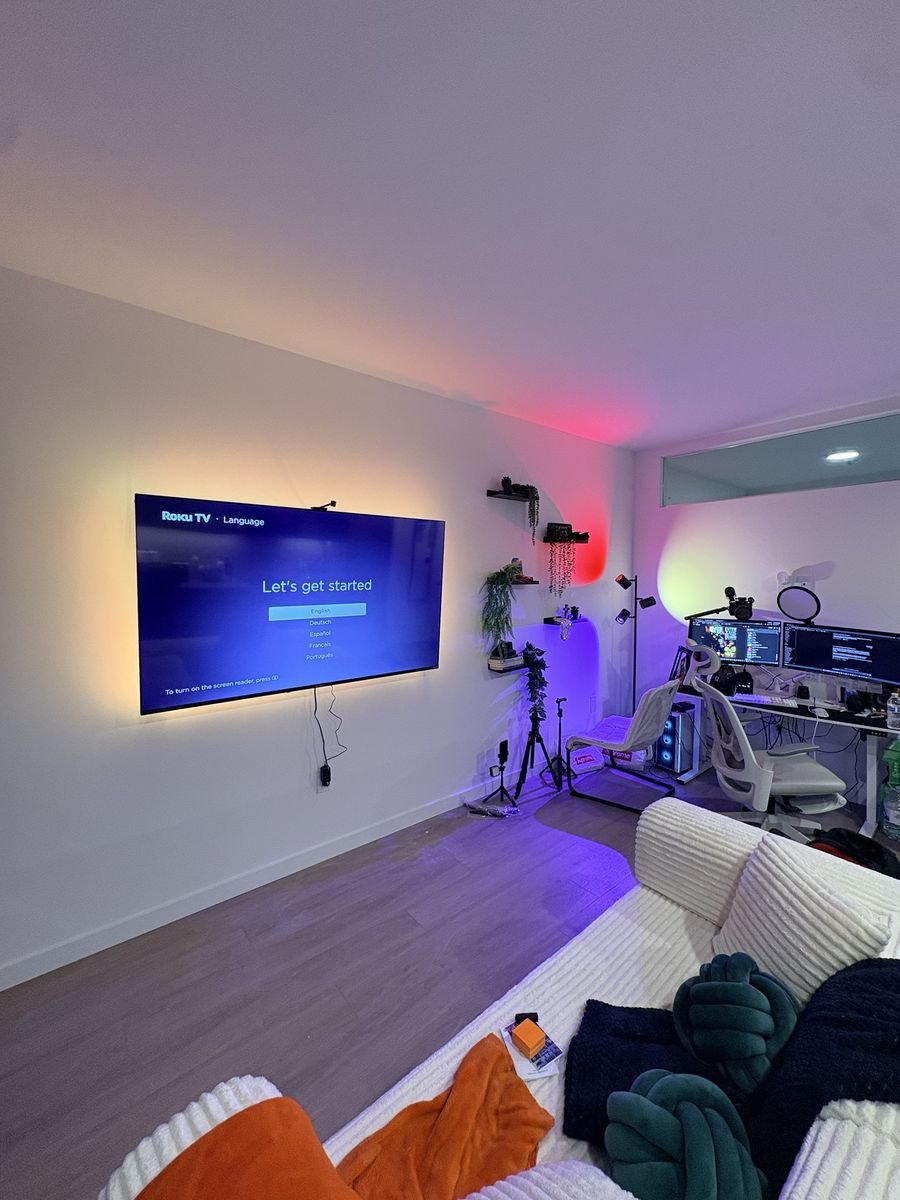 Staggered floating shelves installed beside a wall-mounted TV
